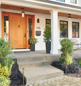 Boyleston LED Path Lights Two Dark Bronze Lights on Display on Each Side of a Front Entrance to a White Home, with Concrete Stairs and Pavers. Off Front View