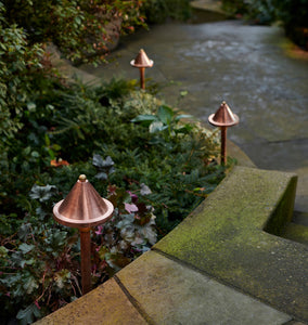 Viola LED Path Lights Three Copper Lights on Display to the Side of a Walkway, Descending Down Stairs, Near Some Foliage