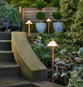 Saratoga LED Path Lights Three Copper Lights on Display to the Side of a Walkway, Descending Down Stairs, Near Some Foliage